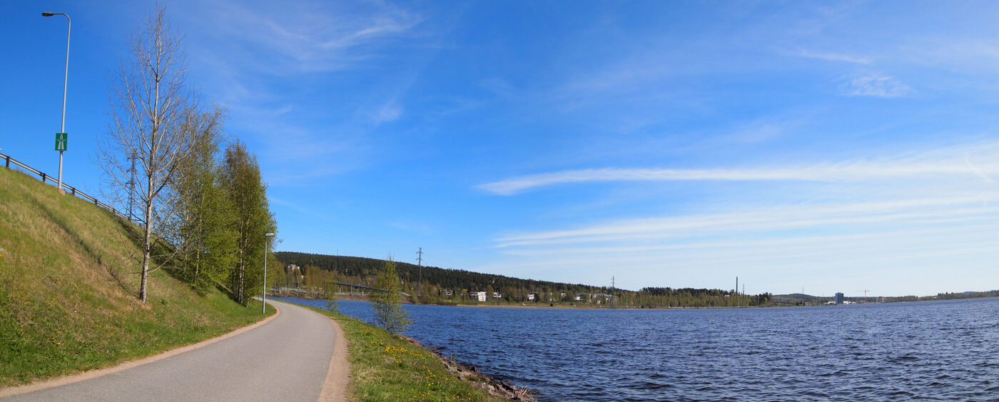 Jyväsjärven rantaraitti Jyväskylässä: leveä kävelytie järven rannassa kesäisen sinisen taivaan alla.